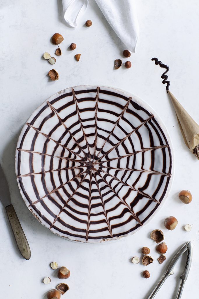 Nusskuchen mit Glasur in Form eines Spinnennetzes